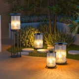 Lanterns lit along a timber deck with pebbles and planting beside them