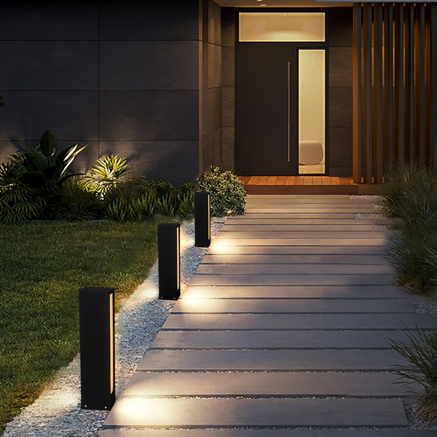 A run lit along a paved walk leading to a lit timber entry doorway