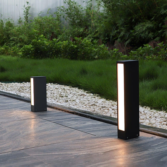 Two lit beside a stone walk with a gravel strip and a green border