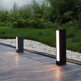 A short and a tall size lit together beside a paved garden walk