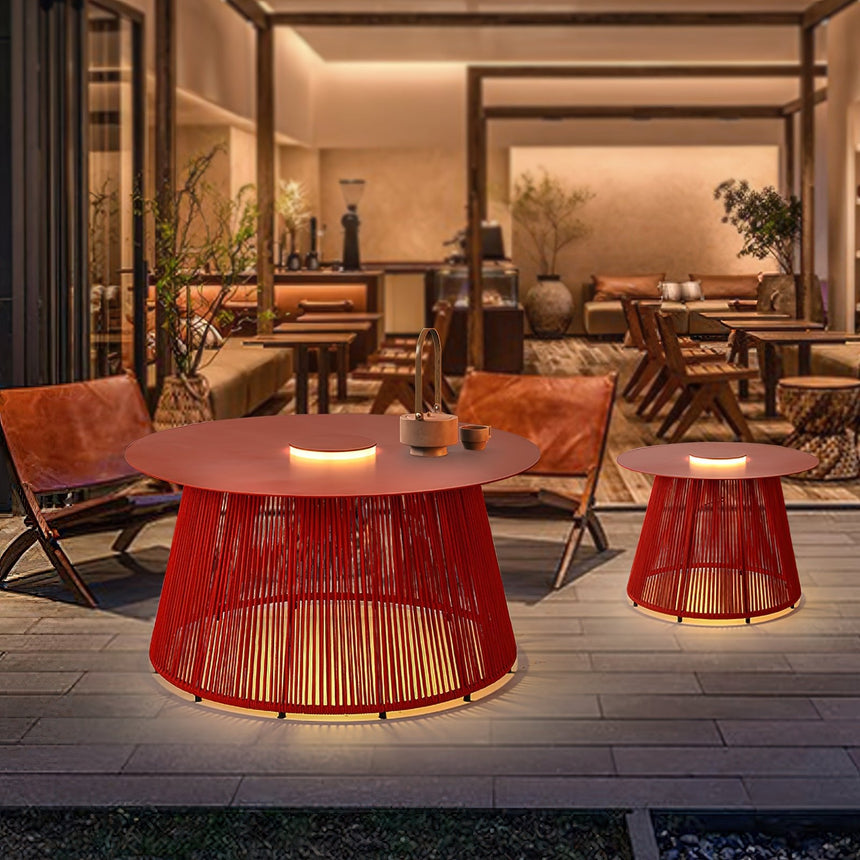 The table lit in a courtyard beside leather armchairs and a timber bar