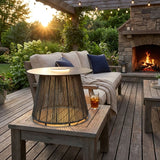 The table lit beside a garden sofa with cushions and a lit fire pit