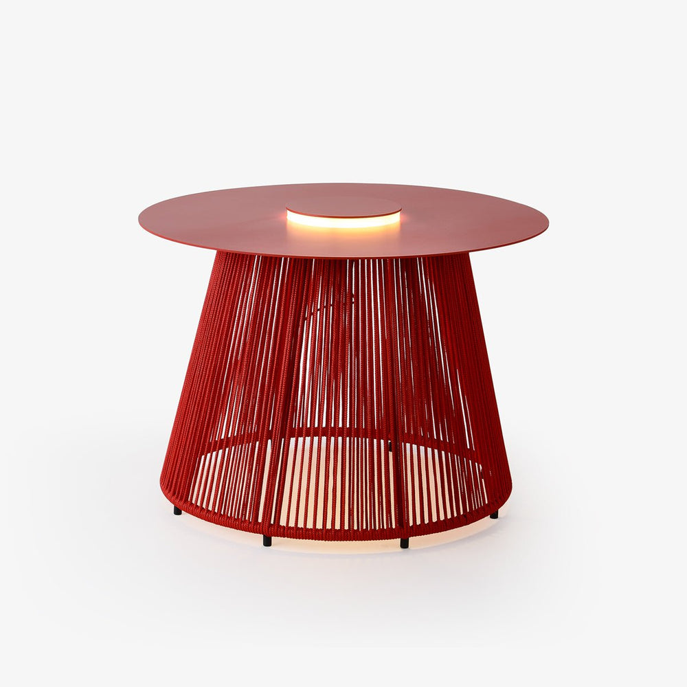 Round low table with a woven cord base glowing under a red top