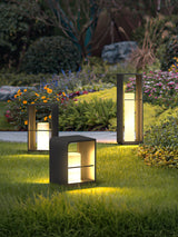 Two sizes lit in a border of low flowers beside a paved terrace