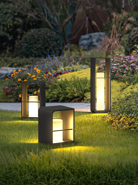 Two sizes lit in a border of low flowers beside a paved terrace