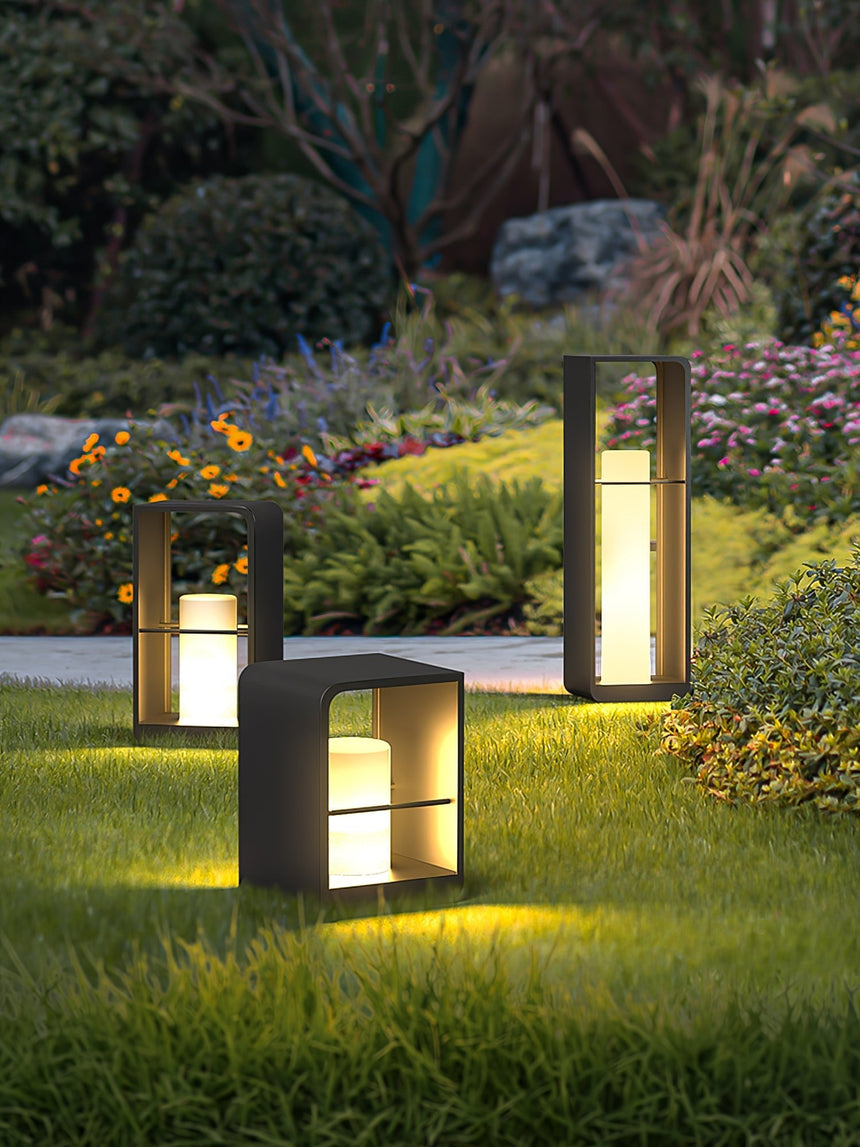 Two sizes lit in a border of low flowers beside a paved terrace