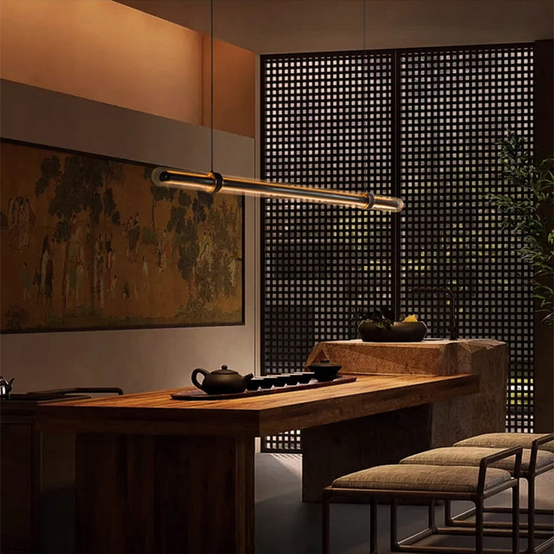 The lit bar hung above a long dining table in a dark wood lined room
