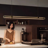 The lit glass bar hung above a dark kitchen counter with shelves behind