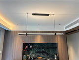 The lit bar hung in a living room above a sideboard with artwork