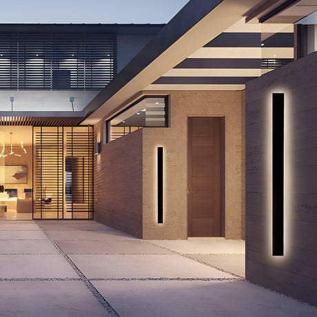 Two linear strips lit on brick walls on either side of a courtyard at dusk