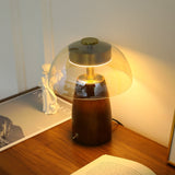 Close view of the clear glass dome and the walnut base below it
