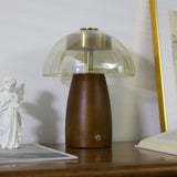 LED table lamp with the clear glass dome seen in full, lit on a desk