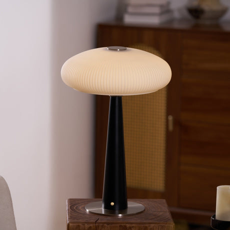 Close view of the fluted opal shade lit above the black cone stem