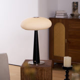 LED table lamp lit in a cool tone against a plain ground