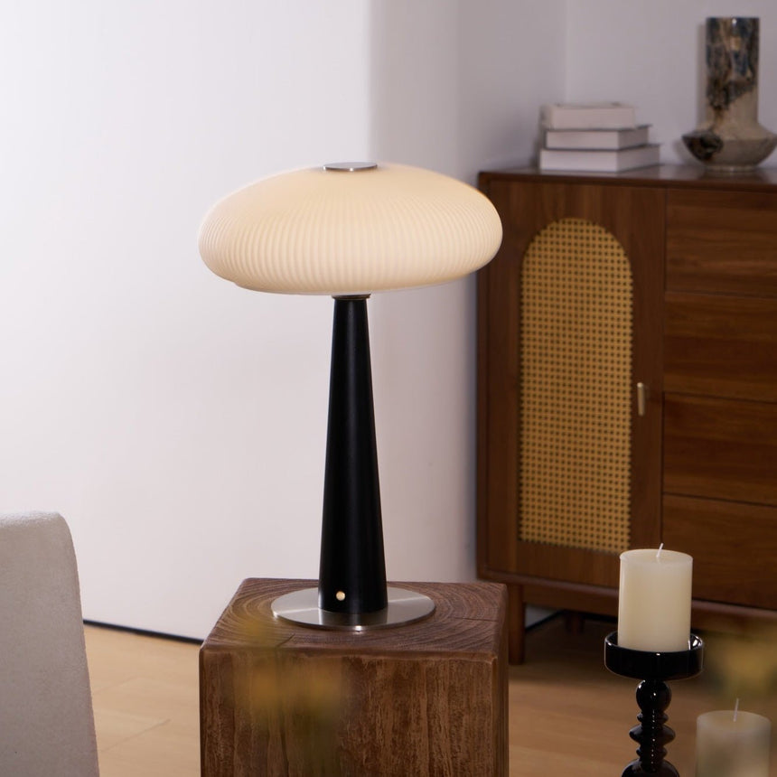 LED table lamp lit in a cool tone against a plain ground