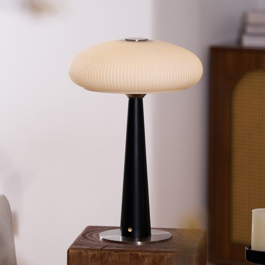 LED table lamp lit in a cool white tone on a wooden plinth
