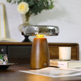 Close view of the lit smoked glass disc above the walnut base