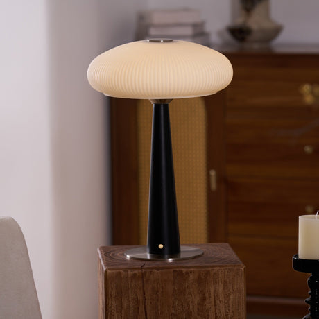LED table lamp lit in front of a cane fronted walnut cabinet