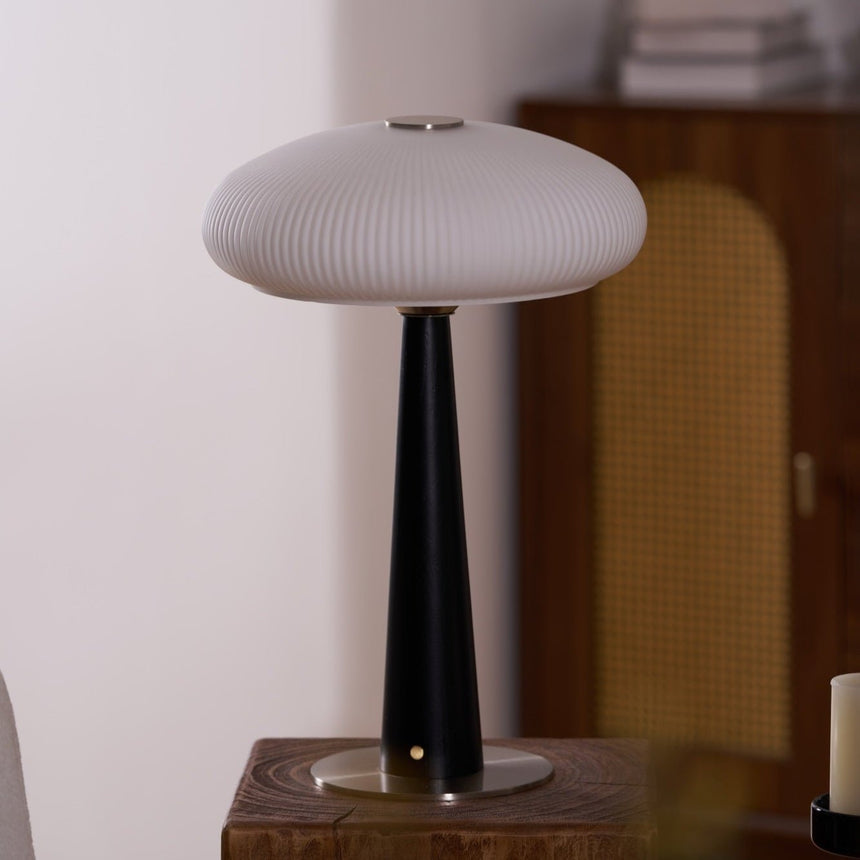 LED table lamp lit on a plinth in a dining corner beside a chair