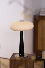 LED table lamp lit and seen from the side on a wooden plinth