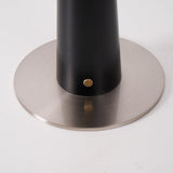 Close view of the brushed metal disc foot and the brass touch point