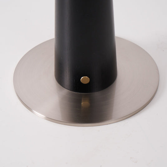 Close view of the brushed metal disc foot and the brass touch point