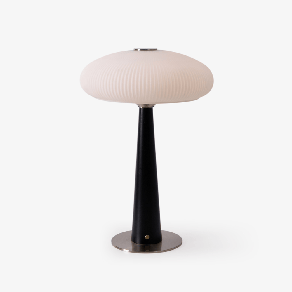 LED table lamp with a fluted opal glass shade on a black cone base, plain ground