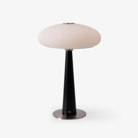 LED table lamp with a fluted opal glass shade on a black cone base, plain ground