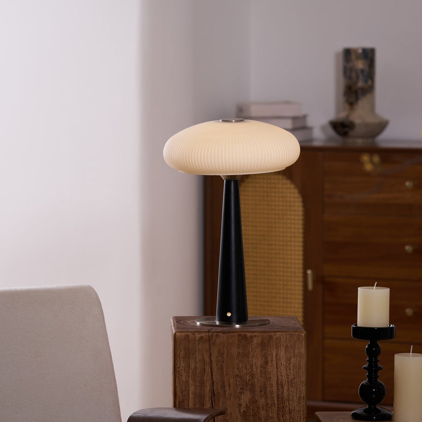 LED table lamp seen from the front on a wooden plinth