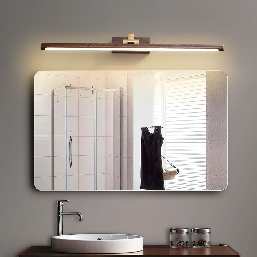 Walnut tone bar lit above a framed mirror over a vessel basin and two candles