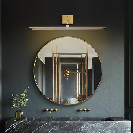 Brass bar lit above a round mirror on a dark wall over a marble basin and plants
