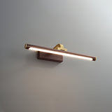 The walnut tone bar seen at an angle, the brass arm behind it against a wall