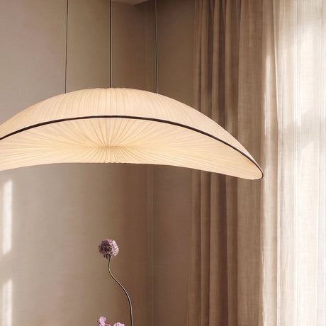 The curved shade lit from within, seen against a plain curtain and a thin stem