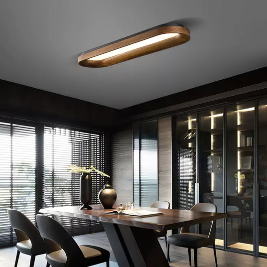 Linear wood frame ceiling light above a dining table beside a glazed wall
