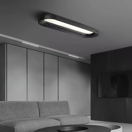Black linear ceiling light in a gray room with a low sofa and a panelled wall