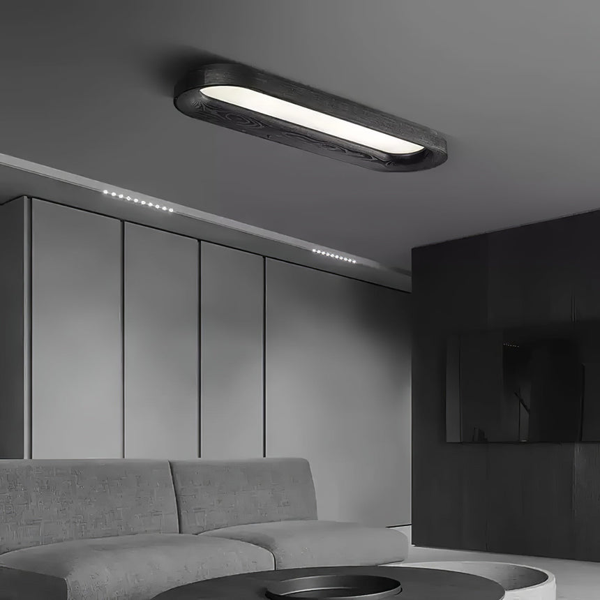 Black linear ceiling light in a gray room with a low sofa and a panelled wall