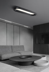 Black linear ceiling light above a pale sofa in a wide gray room