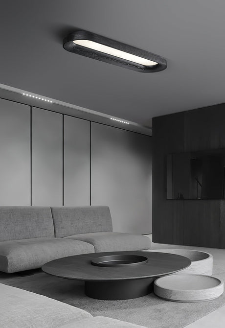 Black linear ceiling light above a pale sofa in a wide gray room