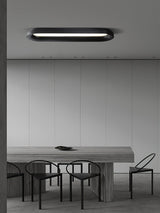 Black linear ceiling light above a long dining table with wire chairs