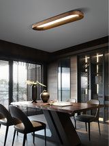 Linear wood frame ceiling light above a dining table with a view outside