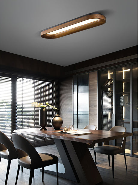 Linear wood frame ceiling light above a dining table with a view outside
