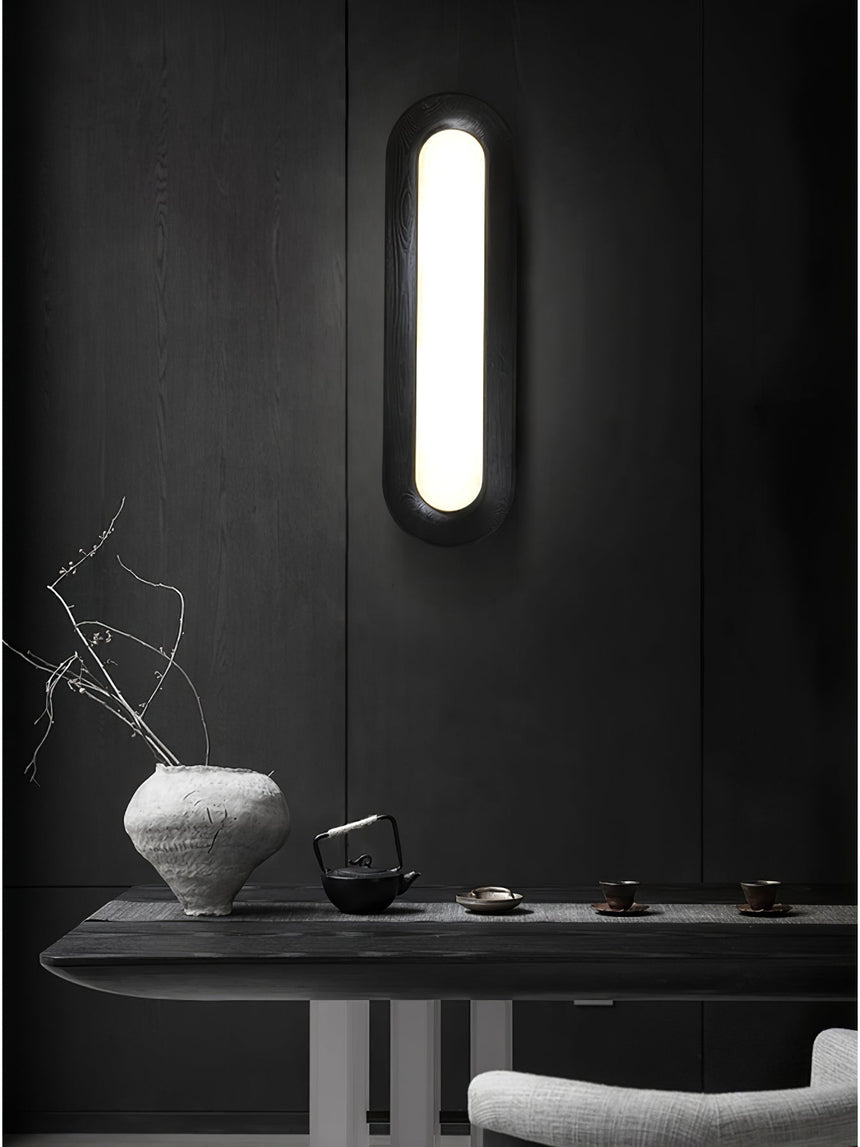 Linear ceiling light mounted vertically on a dark wall above a console