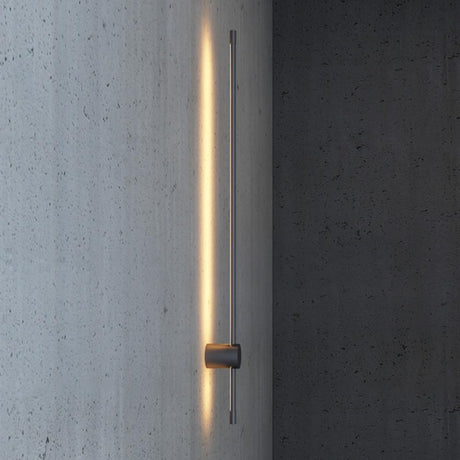 A single rod lit against a concrete wall, the light running the full length