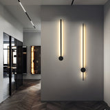 Two rods lit on a dark panel wall along a corridor with parquet underfoot