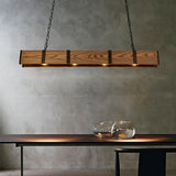 Hung above a dark table and a glass bowl in front of a concrete wall