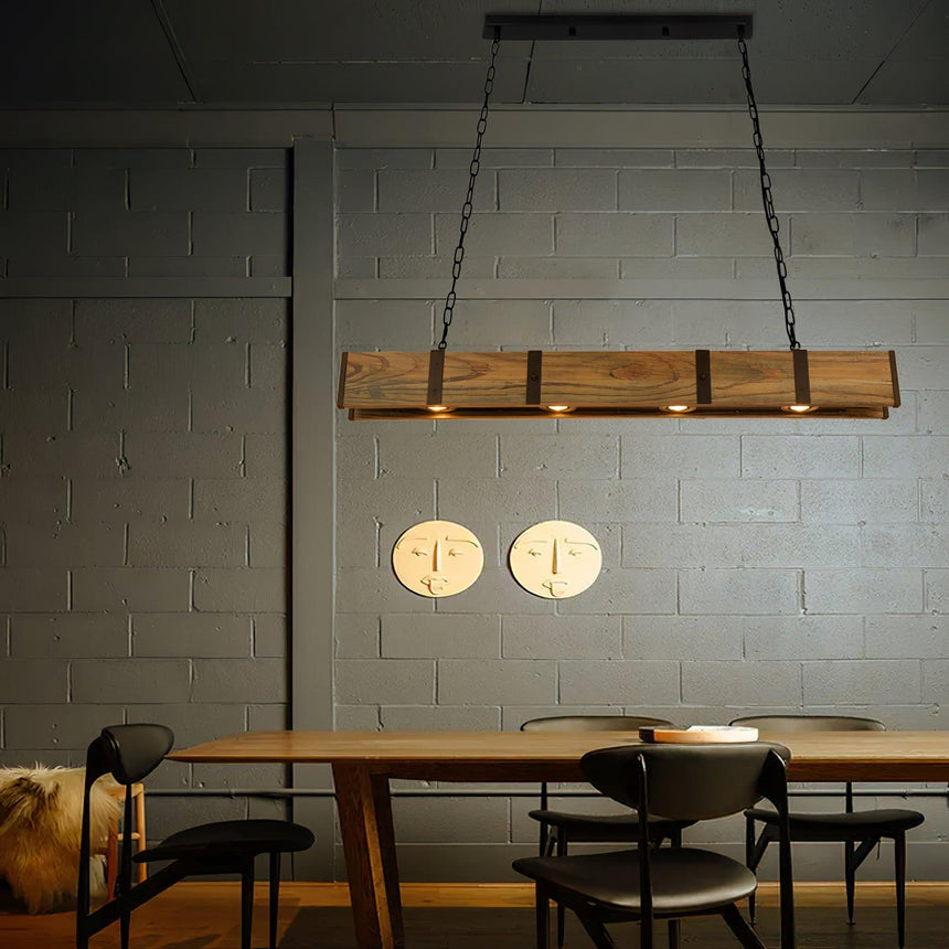 Lit above a table and chairs on a pale block wall hung with two clocks