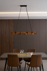 The beam seen across a room under a ceiling cove with a dining set below