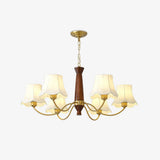 White fabric bell shades with scalloped hems on their brass arms