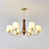 The walnut column and the brass collar the curved arms rise from