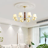 Chandelier lit in a pale living room above a sofa and a plant